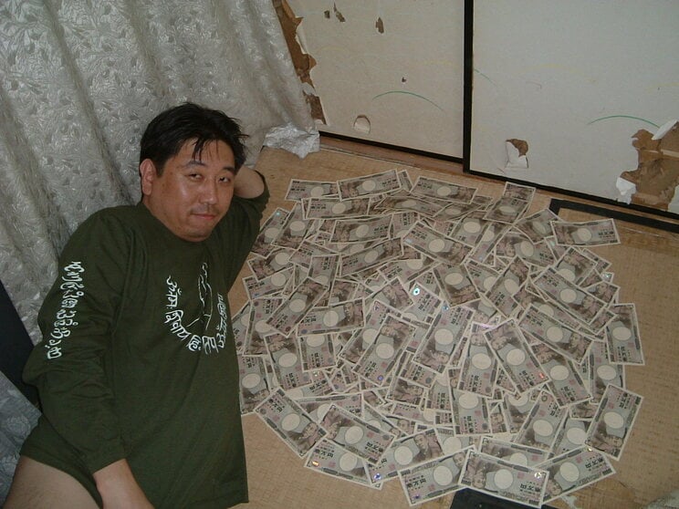 当選直後、口座から2000万円引き出し、部屋に敷きつめて悦に浸る久慈さん