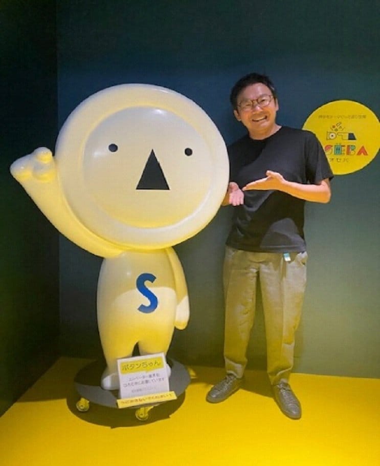 島田正孝社長(右)とイメージキャラクターの「ボタンちゃん」(左)