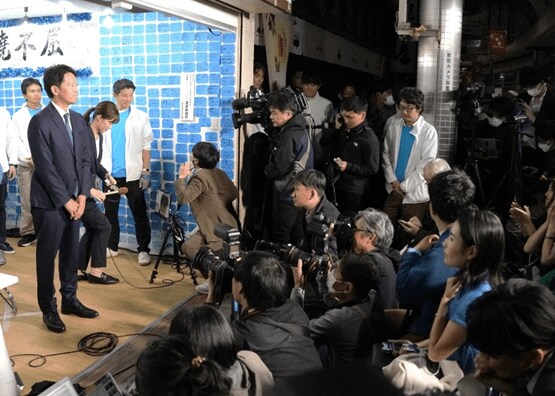 11月17日、斎藤氏を見守る折田氏(右下の青いTシャツの女性)(撮影/集英社オンライン)