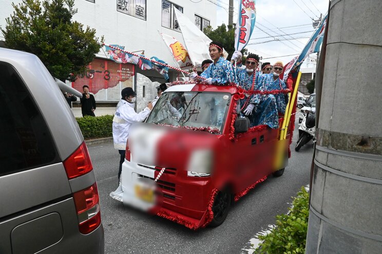 オープンカー状態にした軽ワゴン車に箱乗りする一団（撮影／集英社オンライン））