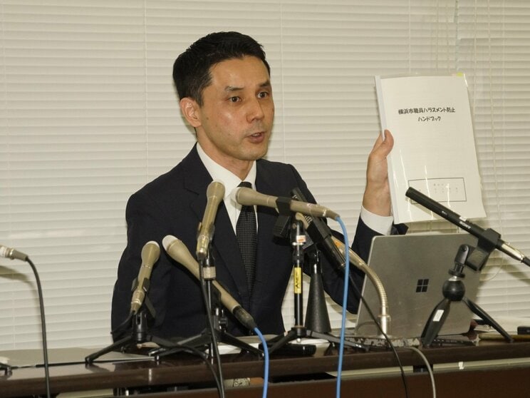 横浜市職員ハラスメント防止ハンドブックを示す久保田淳人事部長（撮影／集英社オンライン）