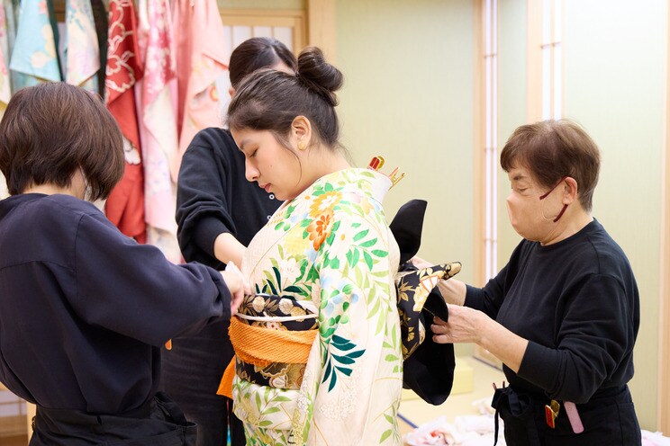 着付けをしてもらう留学生(写真中央)