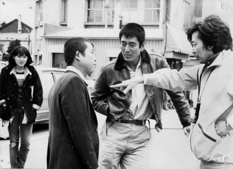 『幸福の黄色いハンカチ』の山田洋次監督に演技指導を受けるたこ八郎。主演、高倉健の姿も。本作品ではチンピラ役で出演し、印象的なヤラレっぷりを見せた