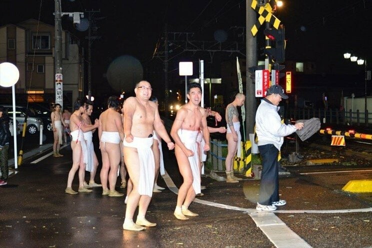 祭りが終了し、凍えながら帰宅を急ぐ参加者。この日は雪まじりの雨が降っていた（2015年3月3日撮影）