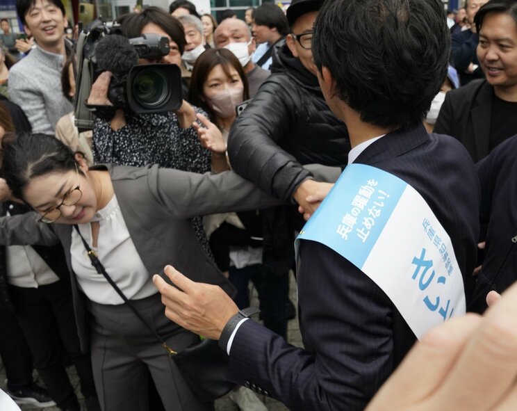 昨年11月16日の知事選最終日、神戸での斎藤元彦氏の街頭演説で聴衆整理をする高見千咲姫路市議(左) 撮影/集英社オンライン