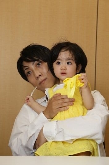 娘・なーちゃんを抱えながらインタビューを受けるタカフミさん(写真/集英社オンライン編集部)