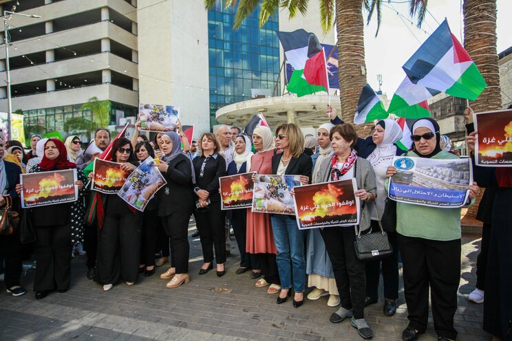 10月17日、ヨルダン川西岸のナブルス市中心部で、戦争反対のプラカードを掲げるパレスチナ女性たち　写真／共同通信