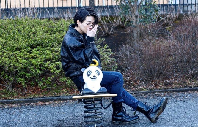 パンダの遊具に乗りながらポーズを決める、オシャレ眼鏡をかけた高橋容疑者