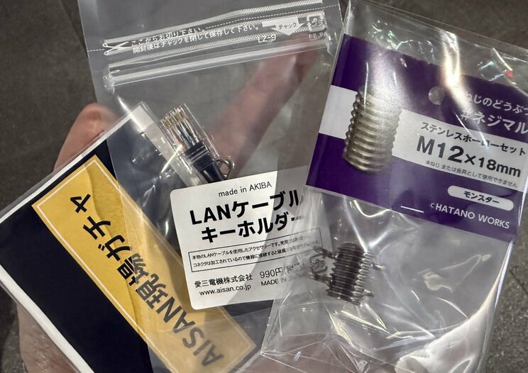 左から現場ガチャ、LANケーブルキーホルダー、ネジマル。ガチャにはメジャーやカラビナなど、現場の人に嬉しいものが封入されている（撮影／集英社オンライン）