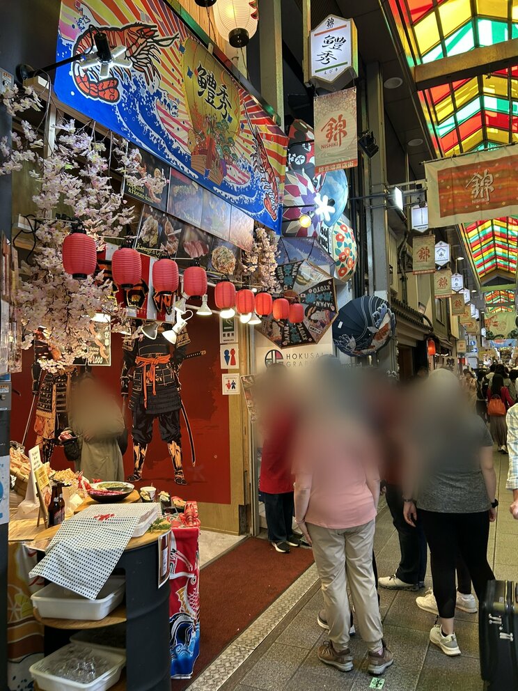 きらびやかな店に目を奪われる観光客たち