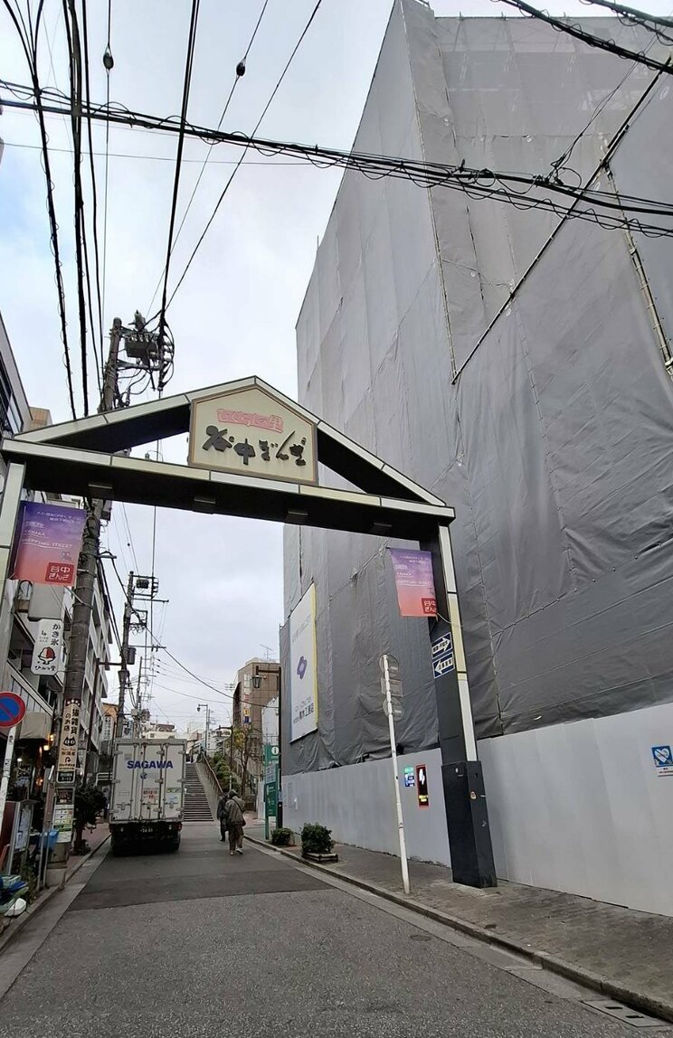 「谷中ぎんざ」のゲートと建設中のマンション（撮影／集英社オンライン編集部）