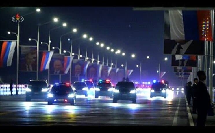 平壌市内の通りを走るロ朝首脳を乗せた車列。通りにはプーチン氏の顔写真が並ぶ（朝鮮中央テレビより）