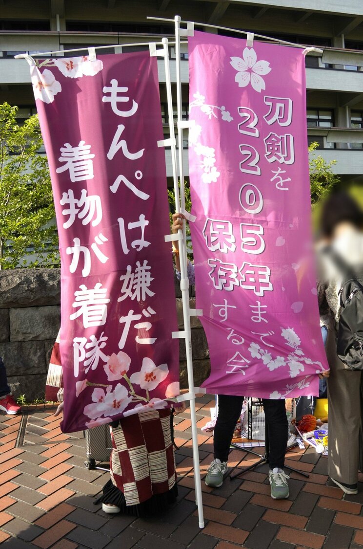 「もんぺは嫌だ着物を着隊」と書いたノボリを持つやよいさん（左）（撮影／集英社オンライン）