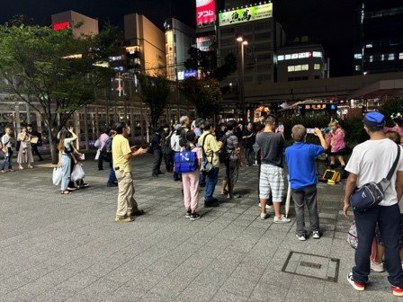 路上ライブの観客で賑わう駅前広場