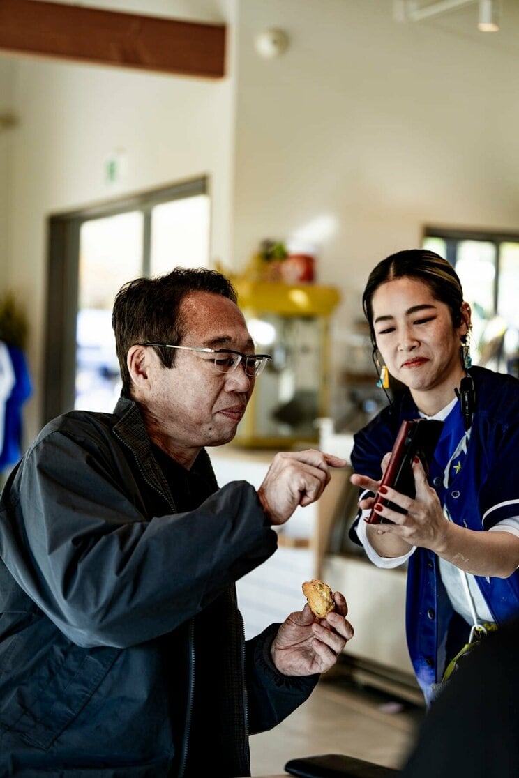 取材は分刻みのスケジュールの合間に。カフェスタッフときさくに会話を交わしながら、朝食を兼ね名物のスコーンを食べる岡田。（写真／近藤 篤）