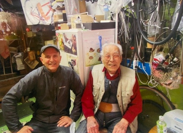 「石井サイクル」店主・石井誠一さん(右)の情報を聞きつけ、店には外国人観光客も訪れる