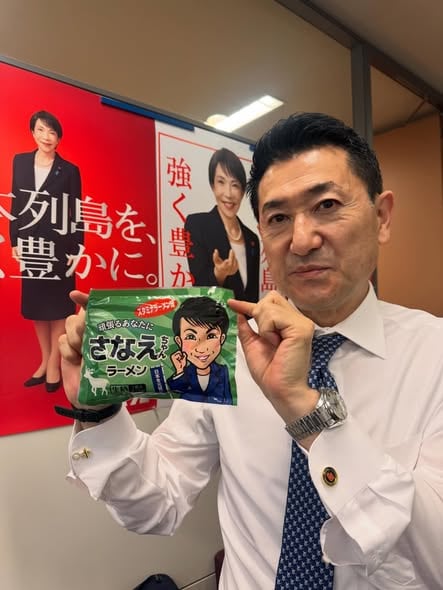 「さなえちゃんラーメン」を手にする赤間防災担当相（本人公式HPより）