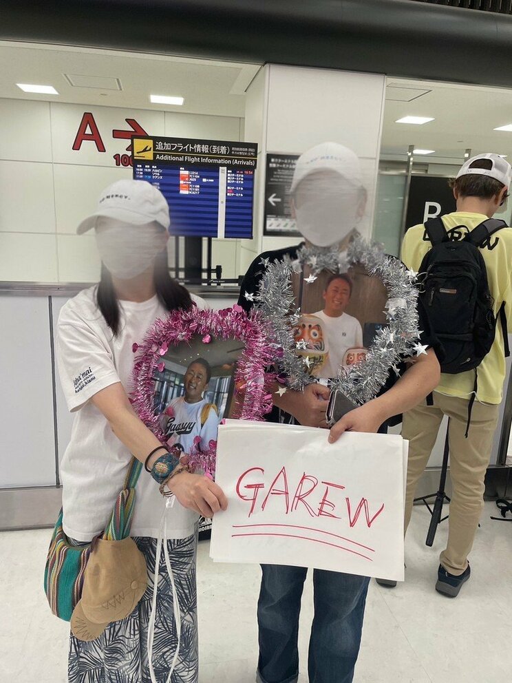 成田空港でタレントを迎えるようにうちわを持って待つガーシー容疑者のファン