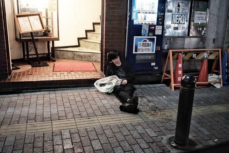 酔いつぶれて路上で眠る男性