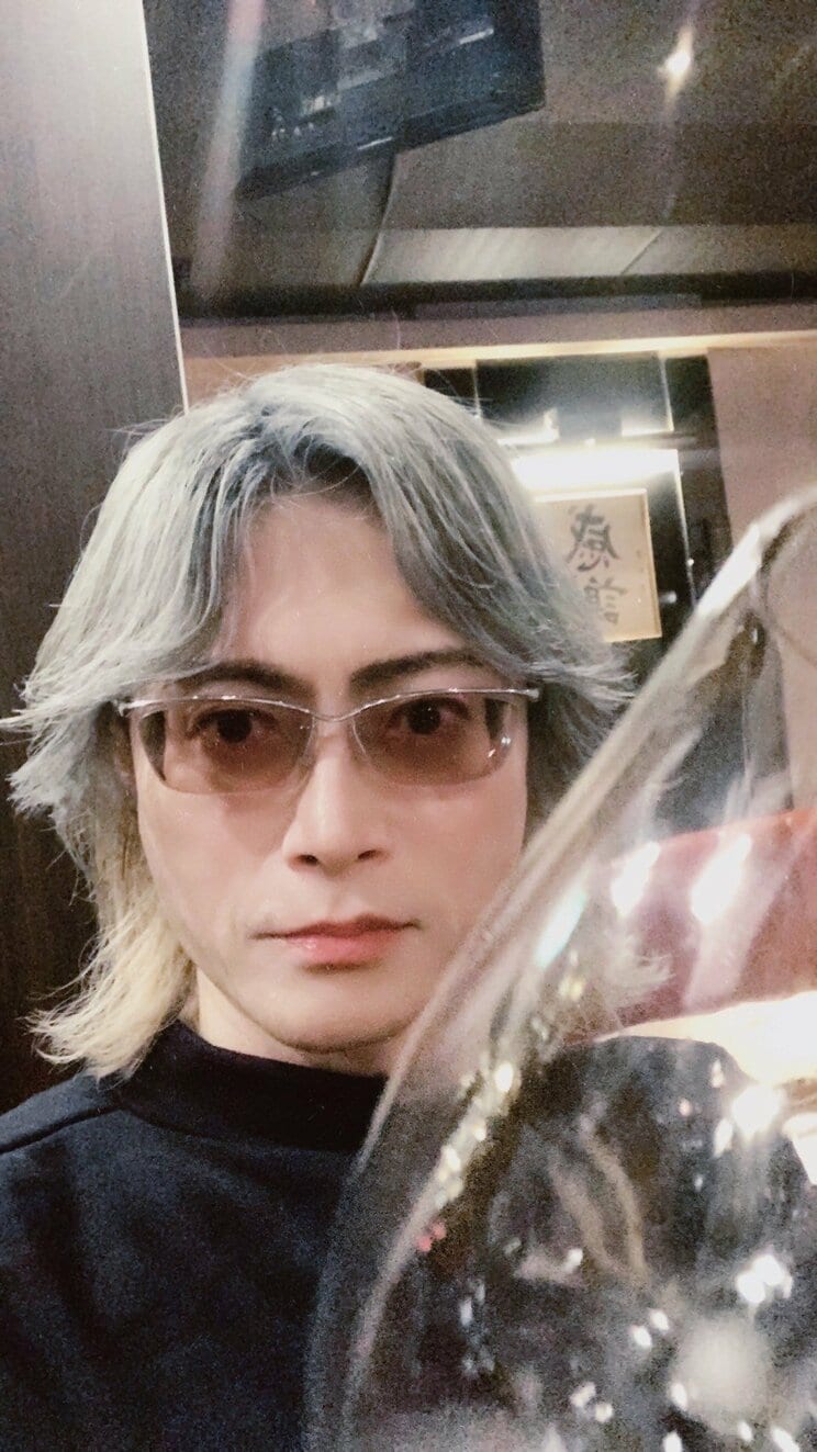 シャンパングラスを持つ頼朝氏。代名詞となった“目ヂカラ”は健在(本人提供)