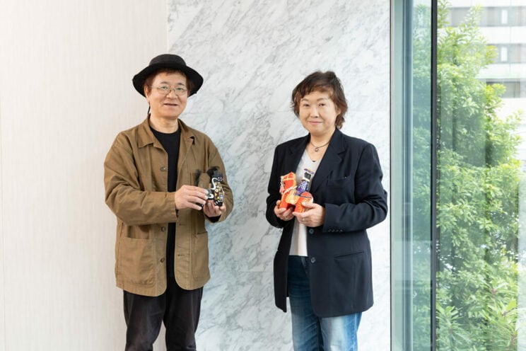 星野さん（右）が手に持っているのは沖縄の郷土玩具「チンチンウマグァー」。張り子の人形で、馬にまたがる王侯をかたどっている。梅崎さん（左）が持っているのは青森・八戸の郷土玩具、八幡馬（やわたうま）。