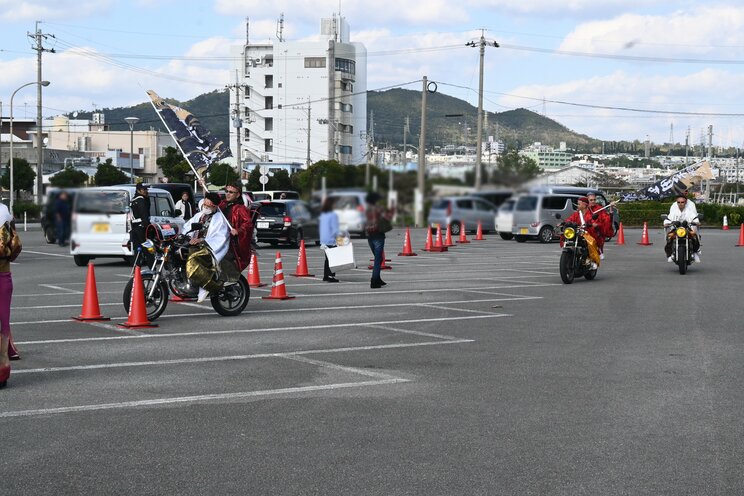 旗竿を振り回しながらバイクで会場に乱入