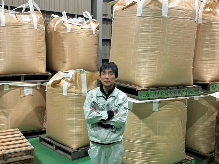 今年収穫したコメと共に取材に応じる岡田さん（撮影／集英社オンライン）