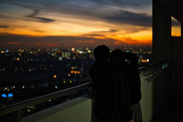 タワマンから夕日を見るカップル　※写真はイメージです