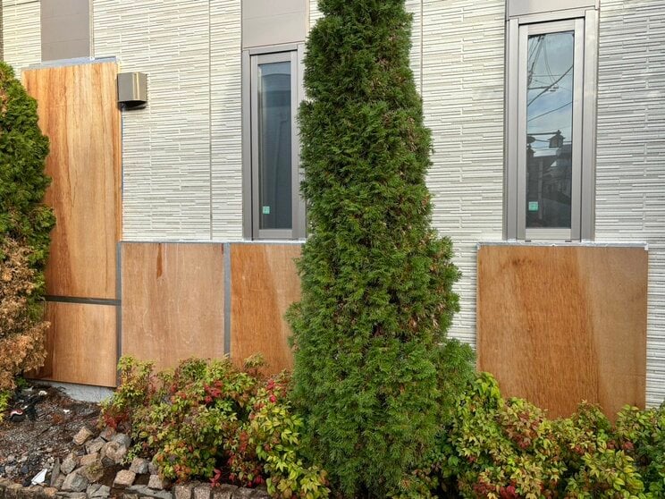 事故2か月後も、車が衝突したアパートの壁は板を張り付けたままだった