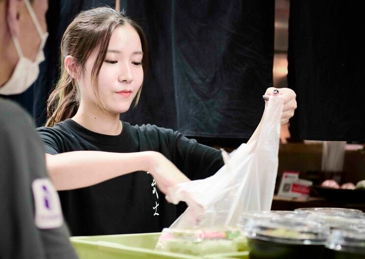 常連さんに弁当を渡す長田さん