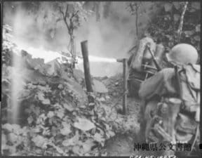 1945年。壕の入り口に向けられた米兵の火炎放射器。沖縄公文書館 蔵