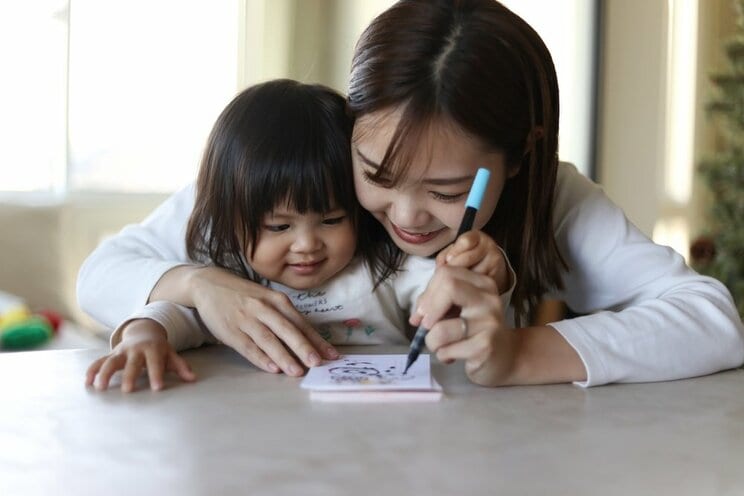 年賀状を楽しそうに作る親子（画像/ Shutterstock）