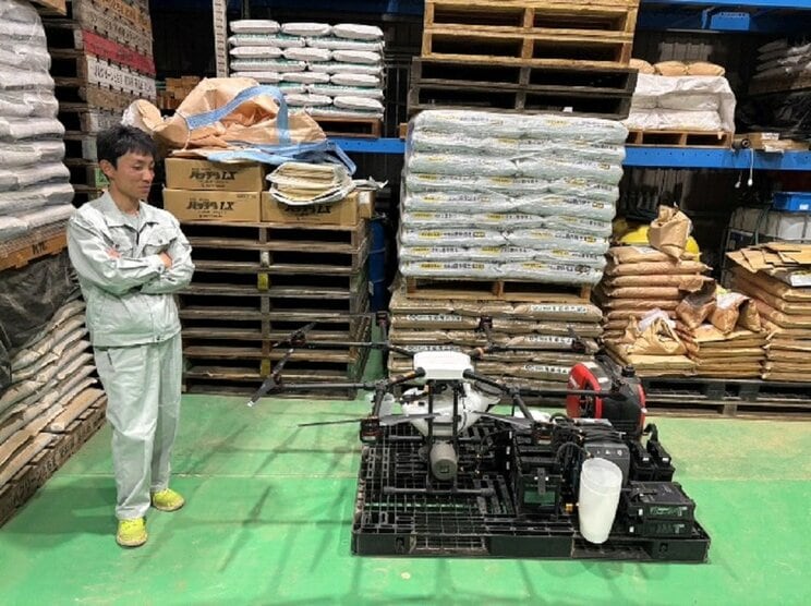 農薬散布に使用するドローンと岡田社長（撮影/集英社オンライン）