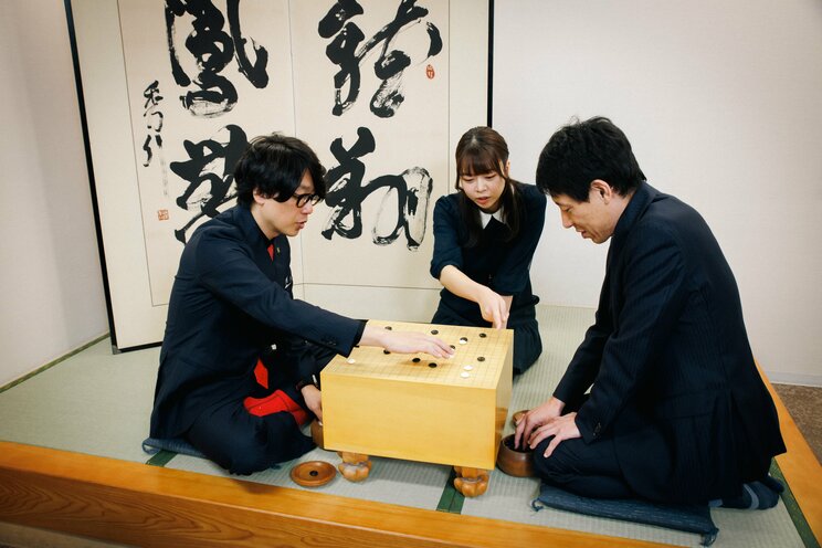 撮影の合間に、直接囲碁を教わる囲碁将棋の2人