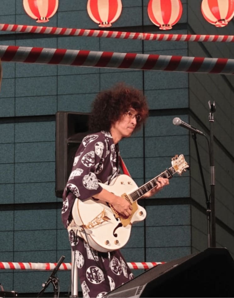 河内家菊水丸バンドでギターを弾くギタリストの幾島学さん（河内家菊水丸公式ブログより）