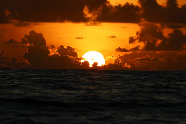 航海中に撮影した水平線に沈む太陽