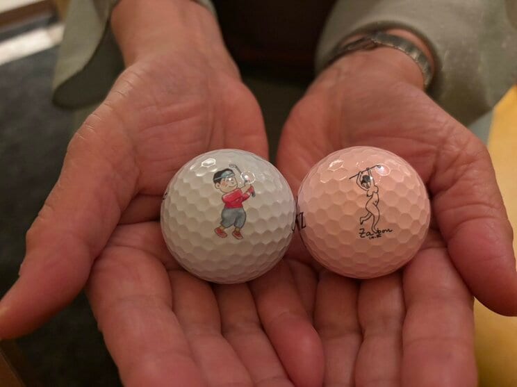漫画家の北見けんいち先生と黒鉄ヒロシ先生のオリジナルイラストが描かれたゴルフボール(撮影/集英社オンライン)