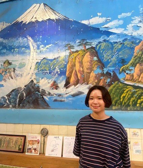 富士山のペンキ絵の前に立つ多田さん