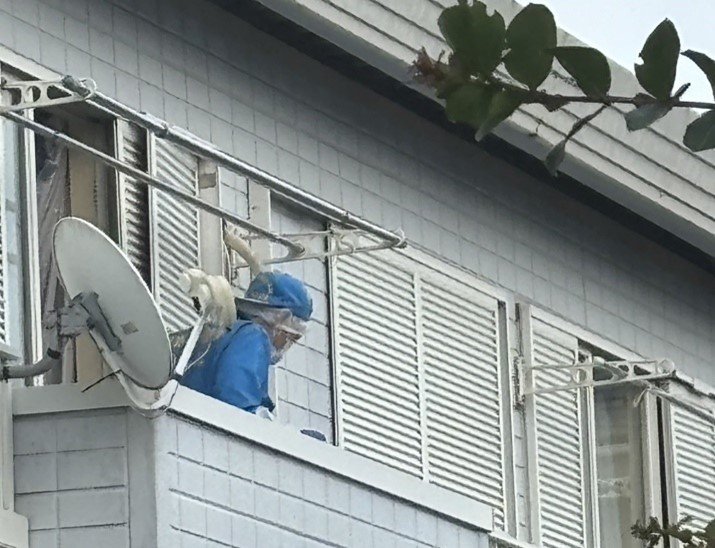 ベランダを出入りする捜査員（撮影／集英社オンライン）