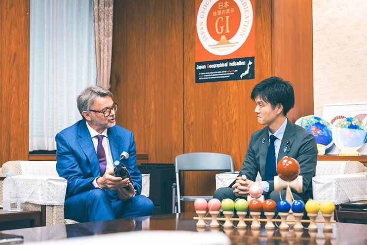 鈴木大臣（右）に自ら造るワインの説明をするトルシエ氏（左）