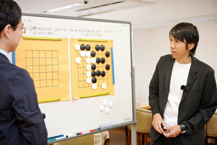 真剣な表情で一力４冠の講義を聞く中村さん。「７×７」での対局の結果は記事ラストの動画でチェック！