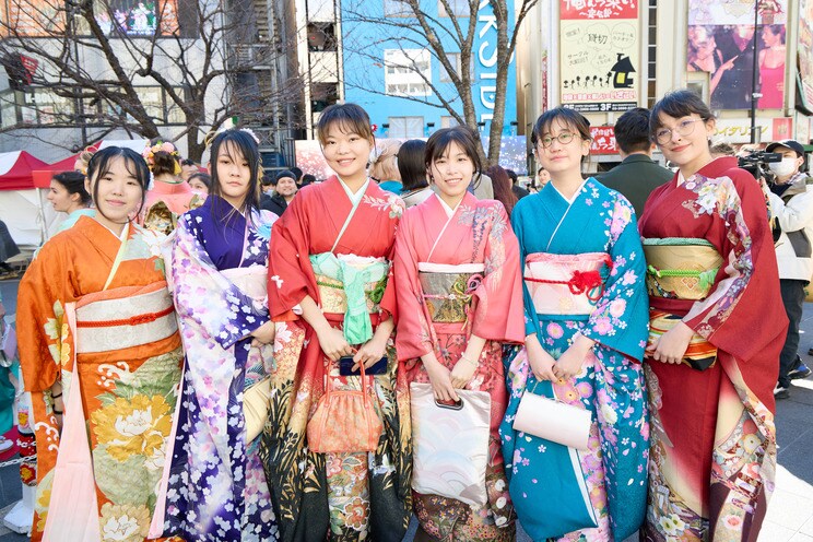 赤の振袖を身にまとい集合写真に収まる留学生たち