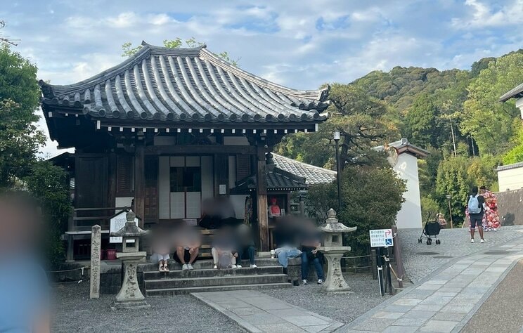 お堂の階段に座り込む外国人観光客