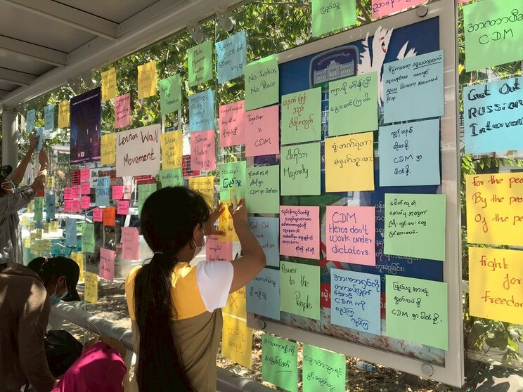 大学生たちが、バス停に「自由のために闘おう」など書かれたメッセージを貼っている。非暴力運動のひとつ（写真／西方ちひろ）