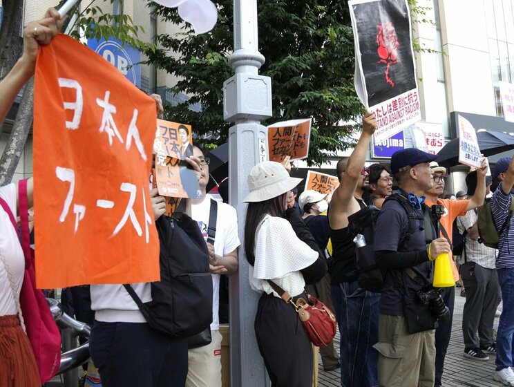 7月13日、成増駅前の参政党演説会。日本人ファーストと書いた横断幕と、それに抗議する「人間にファーストもセカンドもない」と書かれたプラカードが並んだ（撮影／集英社オンライン）