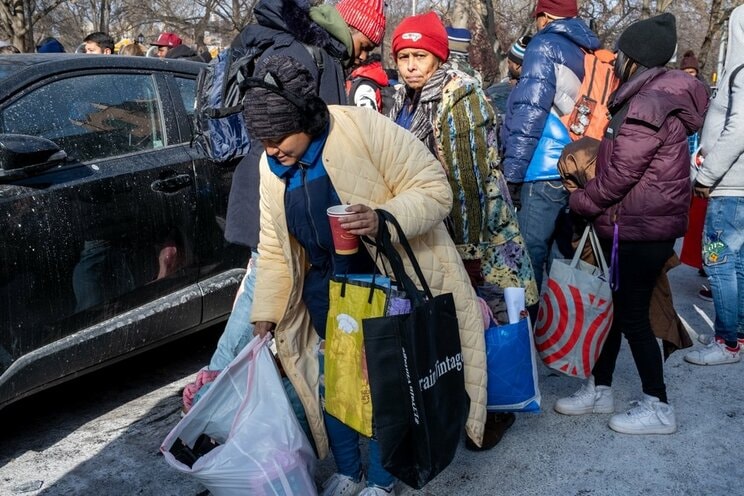 ニューヨークで寄付された衣類や食料品でいっぱいのバッグを持った移民女性　写真／shutterstock