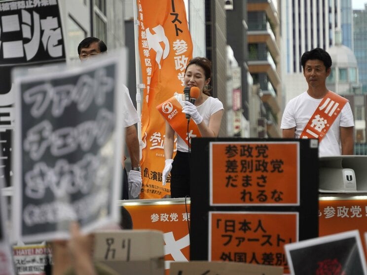 7月19日、銀座で演説する参政党のさや氏と抗議のプラカード（撮影／集英社オンライン）