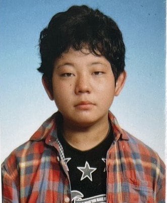 チェックのシャツを着る少年時代の江口容疑者