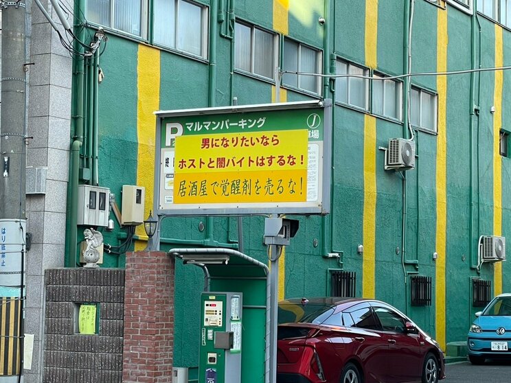 駐車場看板の上に衝撃的なコピーが躍る