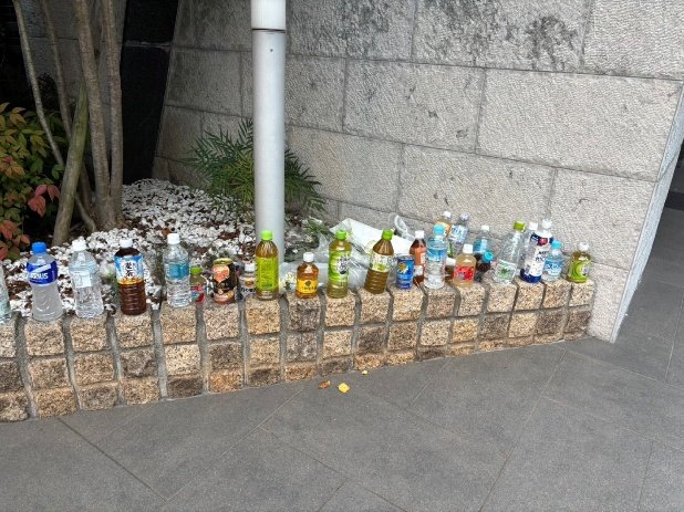 現場となったマンションの前には事件後多くの供え物が（撮影／集英社オンライン）